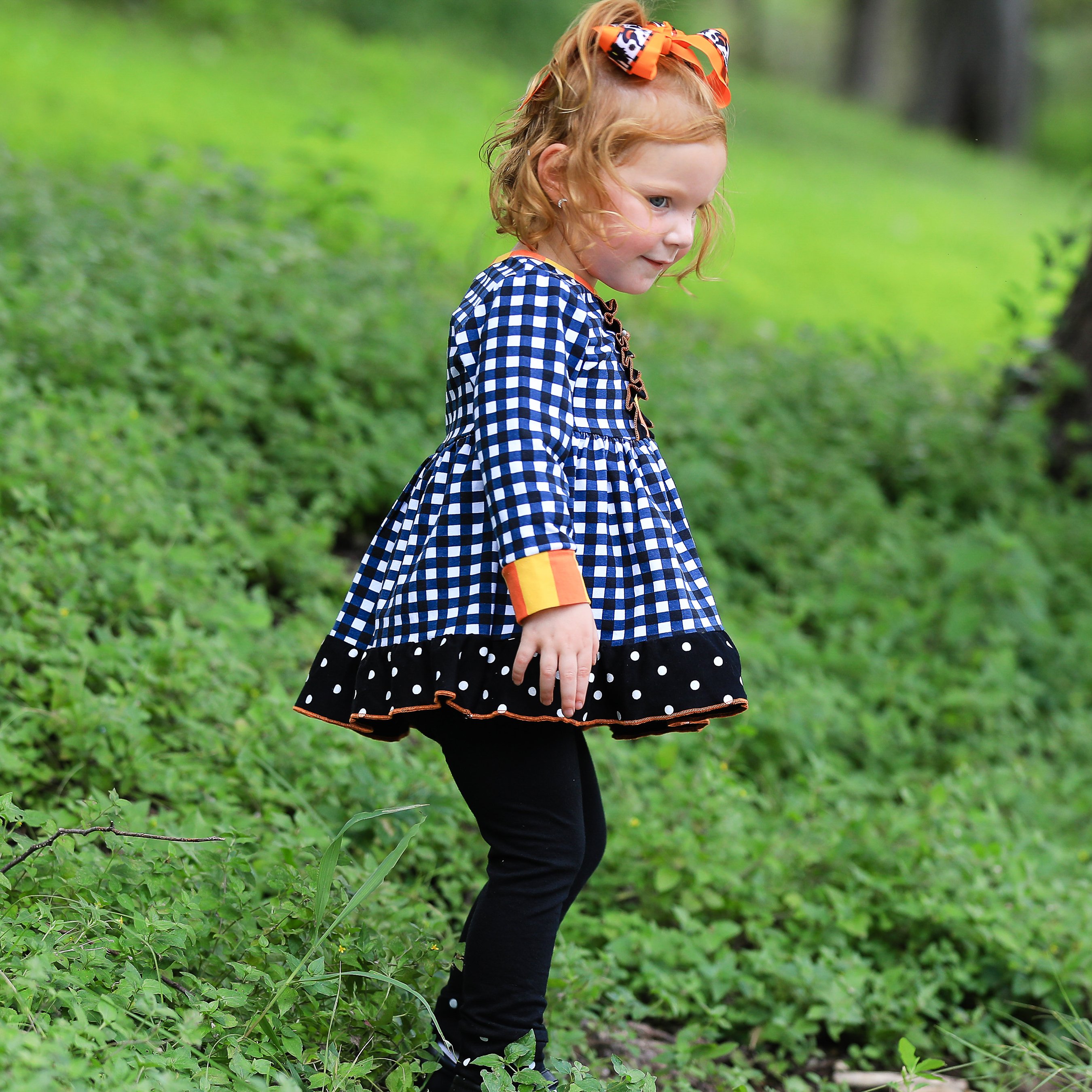 AnnLoren Girls Autumn outfit featuring a black and white gingham dress with polka dot ruffle trim and black leggings with ruffle trim.